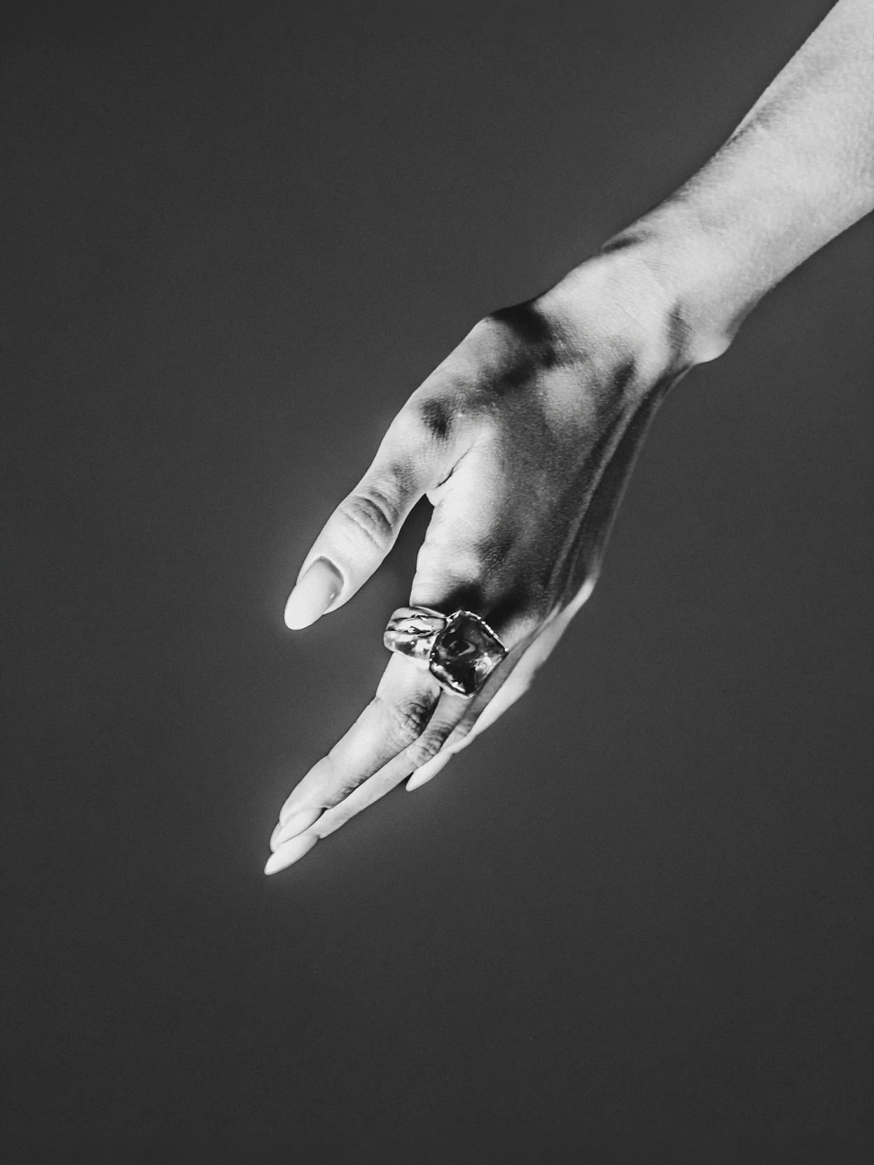 Fine-art B&W hand study with sculptural silver ring — silver-jewelry campaign